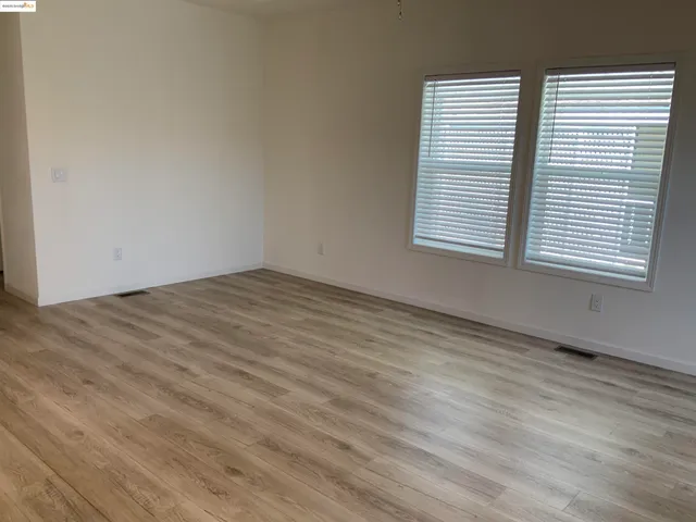 an empty room with wooden floor and a window