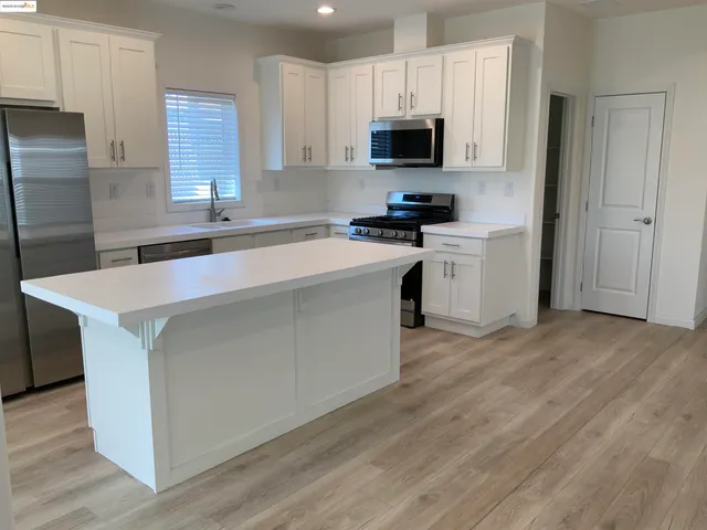 a kitchen with stainless steel appliances a microwave sink and refrigerator