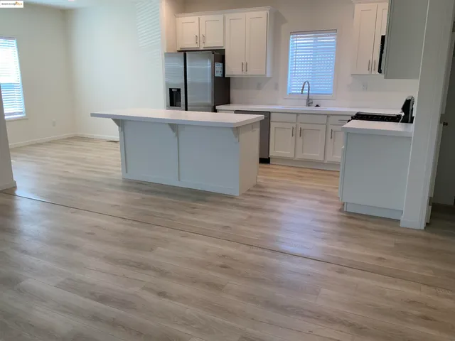 a kitchen with a sink cabinets and wooden floor