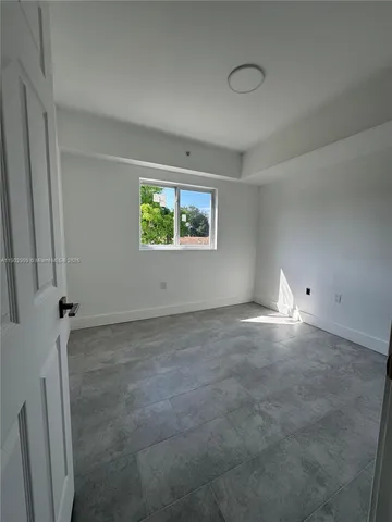 a view of empty room with furniture and a refrigerator