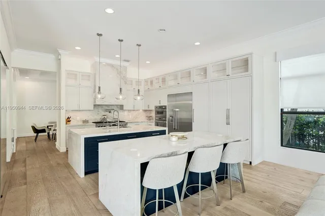 a kitchen with stainless steel appliances kitchen island granite countertop a stove a sink and a white cabinets