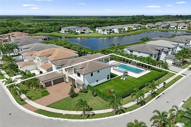 an aerial view of residential houses with outdoor space and lake view
