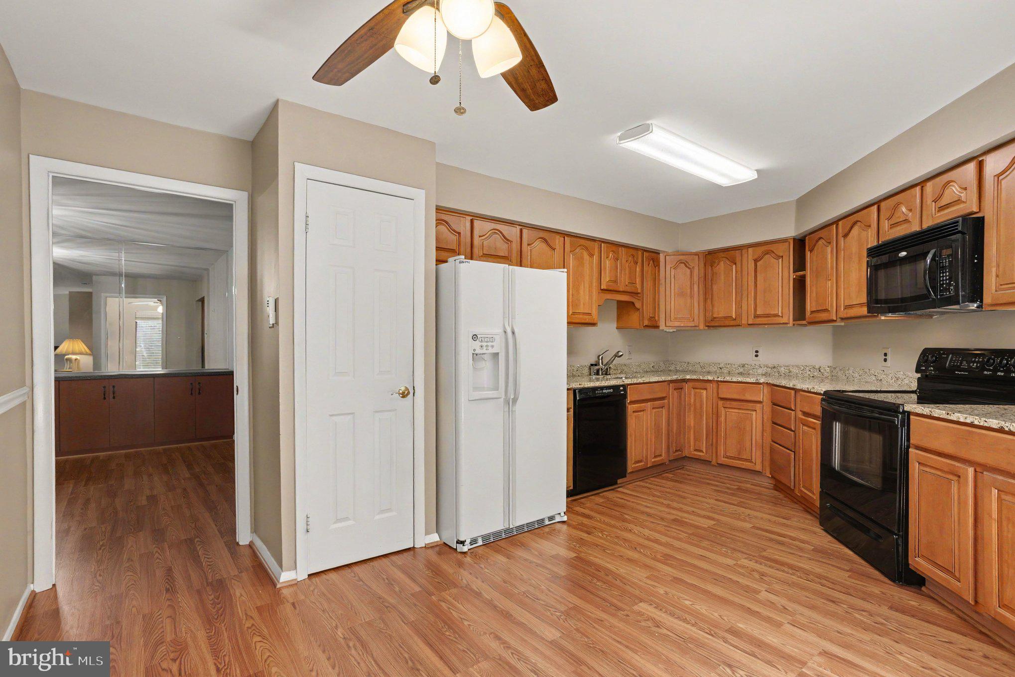 3021 Fallstaff Road, Unit 208B Baltimore, MD 21209 - Photo 10 of 25 a kitchen with stainless steel appliances granite countertop a refrigerator a sink dishwasher a stove with wooden cabinets and floor