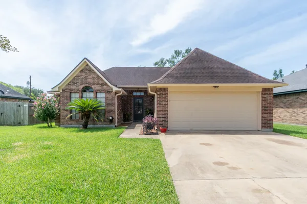 a front view of a house with a garden and yard