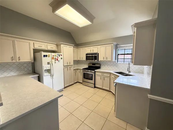 a kitchen with white cabinets and stainless steel appliances