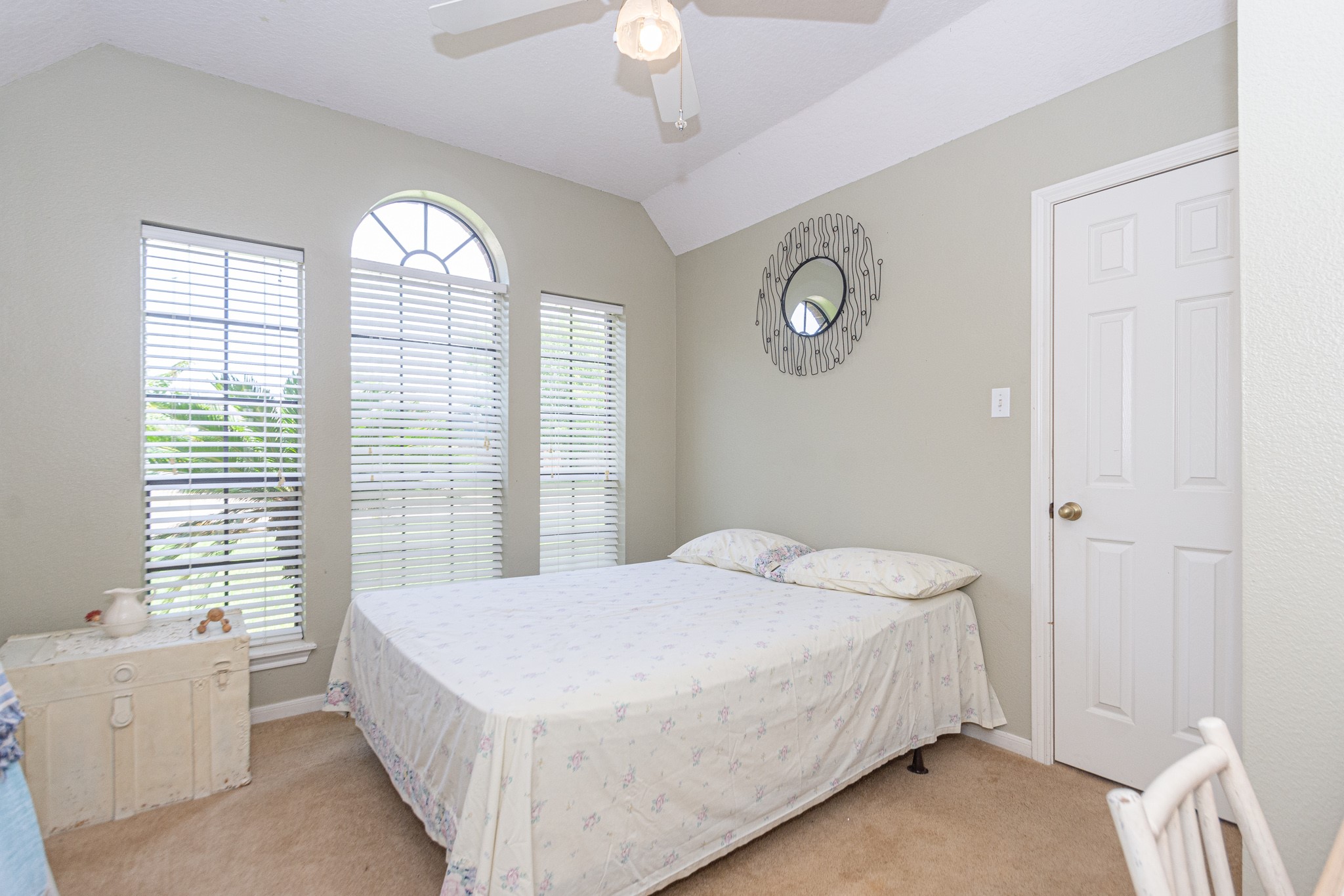 808 Manor Drive Angleton, TX 77515 - Photo 13 of 31 a bedroom with a large bed and a chandelier