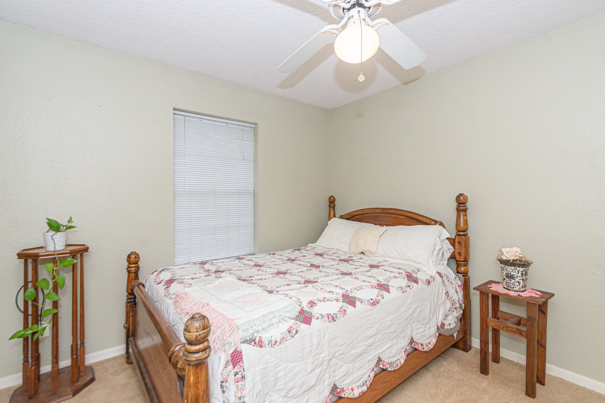 808 Manor Drive Angleton, TX 77515 - Photo 17 of 31 a bedroom with a bed and a chandelier