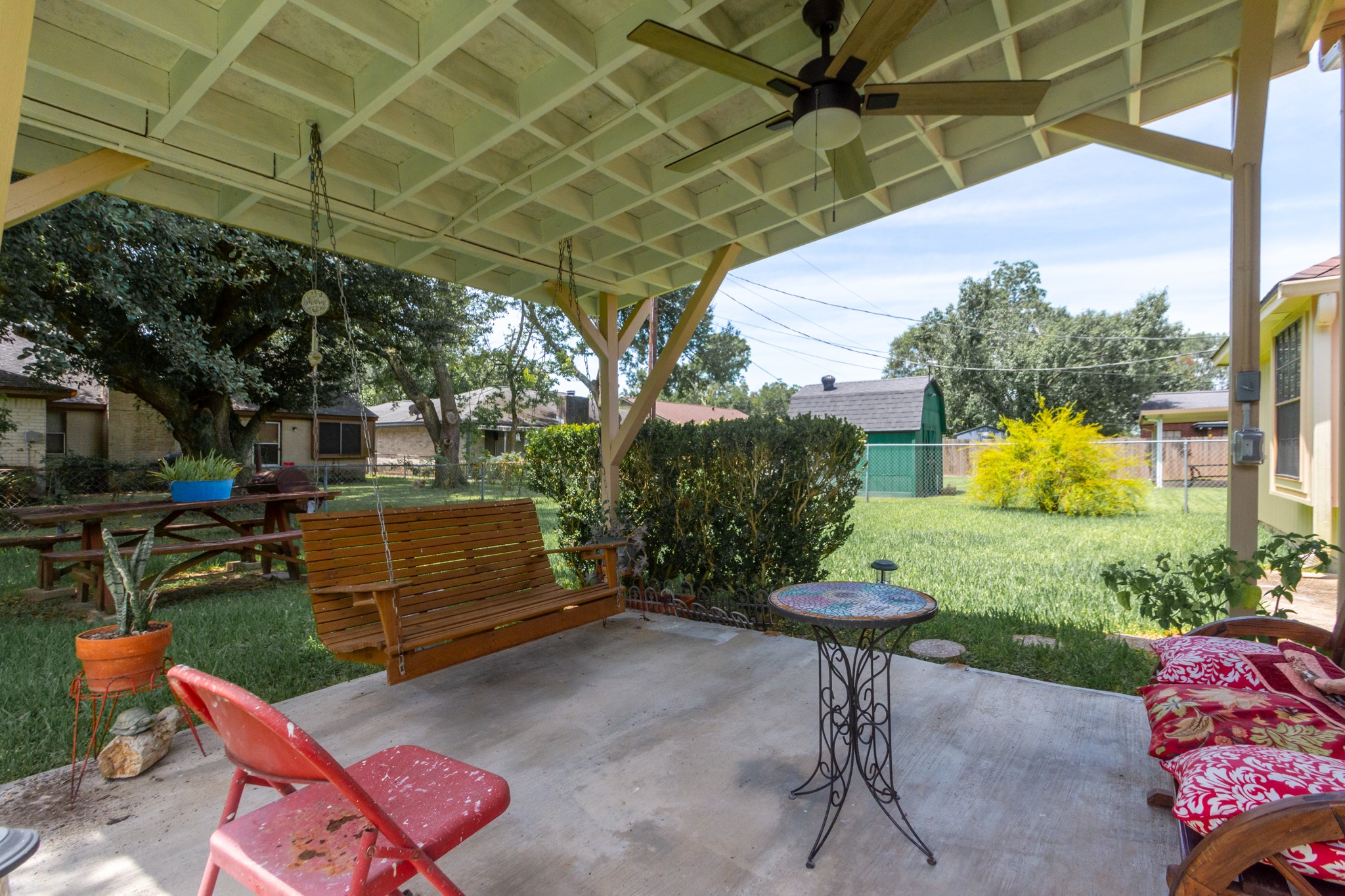 808 Manor Drive Angleton, TX 77515 - Photo 26 of 31 a view of a backyard with table and chairs potted plants and a palm tree