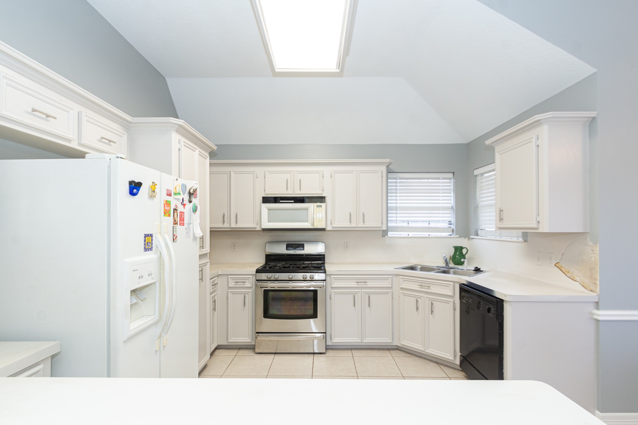 808 Manor Drive Angleton, TX 77515 - Photo 8 of 31 a kitchen with stainless steel appliances a refrigerator sink and cabinets