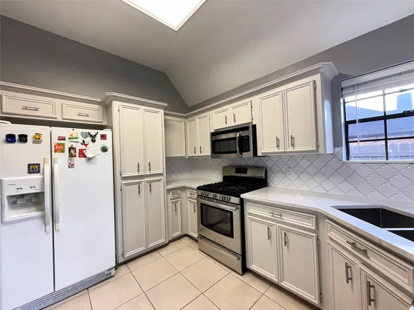 a kitchen with white cabinets and white appliances