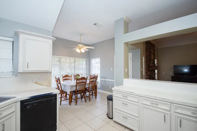 a kitchen with a dining table chairs and white cabinets