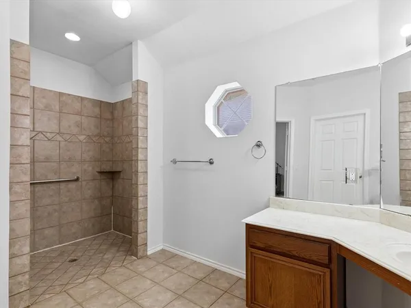 a bathroom with a granite countertop sink a mirror and shower