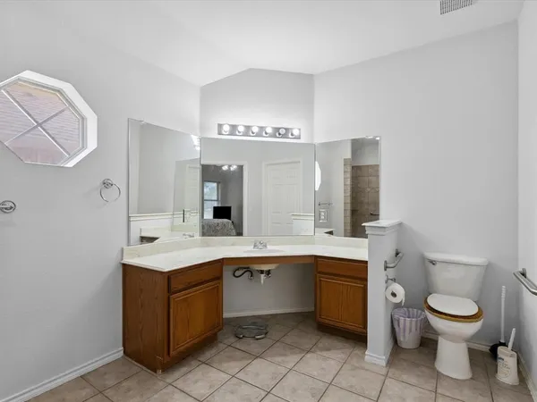 a spacious bathroom with a toilet sink and mirror
