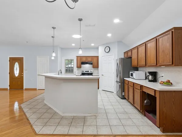 a large kitchen with stainless steel appliances lots of counter space and wooden floor