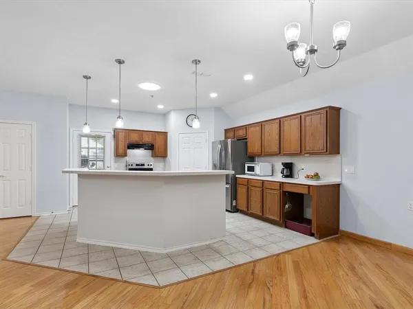 a large kitchen with kitchen island a island a stove a sink a center island and stainless steel appliances