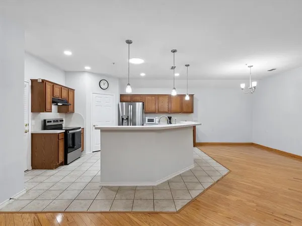 a large kitchen with a large counter top stainless steel appliances and cabinets