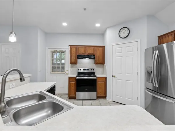 a kitchen with stainless steel appliances granite countertop a sink stove and refrigerator