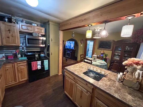 a kitchen with stainless steel appliances granite countertop a sink a stove and a wooden floors