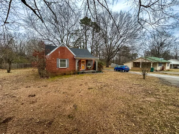 a front view of a house with a yard covered with snow