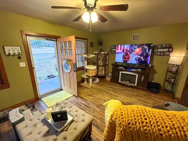 a living room with furniture a flat screen tv and kitchen view