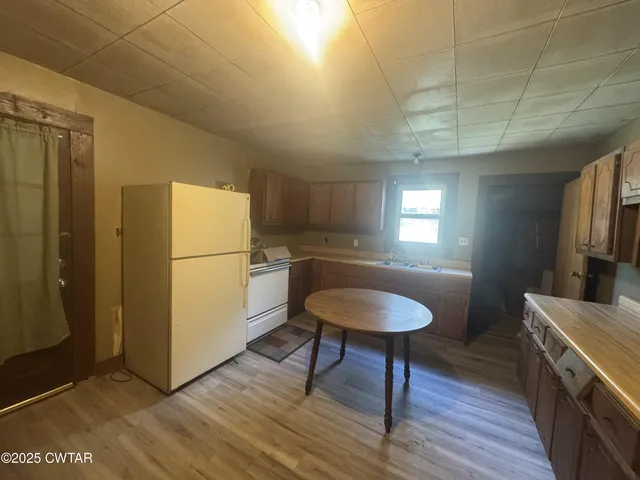 a kitchen with a sink cabinets and wooden floor