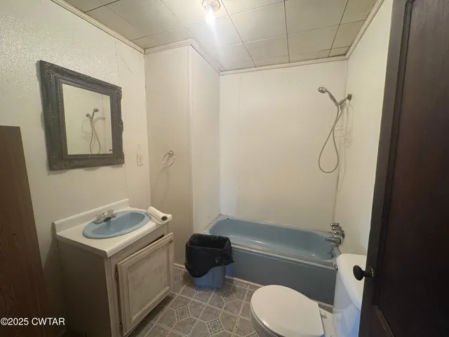 a bathroom with a granite countertop bathtub shower sink vanity and toilet
