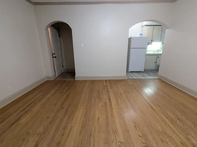 a view of empty room with wooden floor