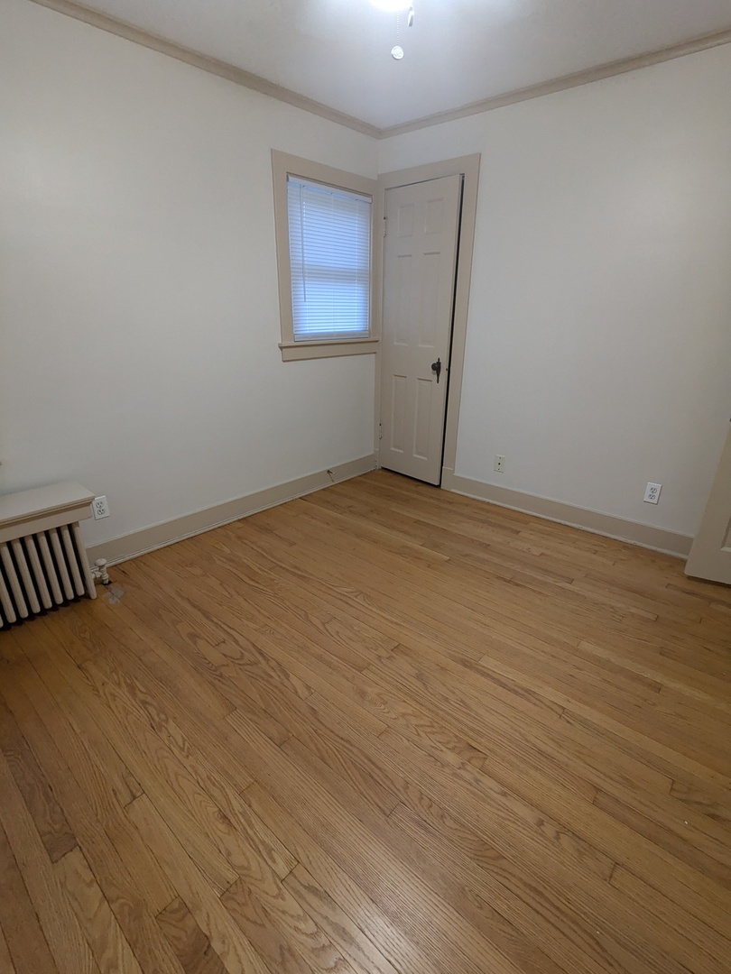 328 West St Charles Road, Unit B2 Lombard, IL 60148 - Photo 15 of 26 a view of an empty room with wooden floor and a window