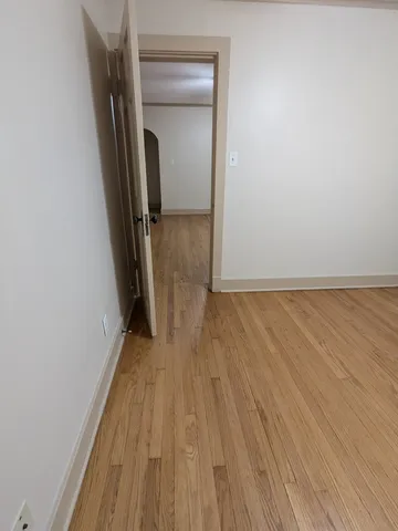 a view of a room with wooden floor and a hallway