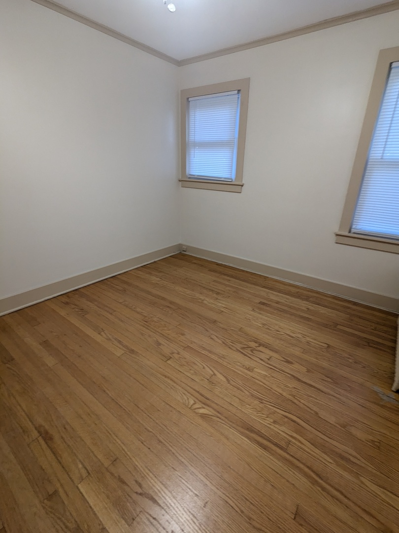 328 West St Charles Road, Unit B2 Lombard, IL 60148 - Photo 17 of 26 a view of an empty room with wooden floor and a window