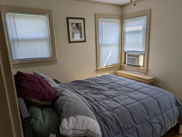 a bed sitting in a bedroom next to a window