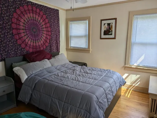 a bedroom with a bed and wooden floor
