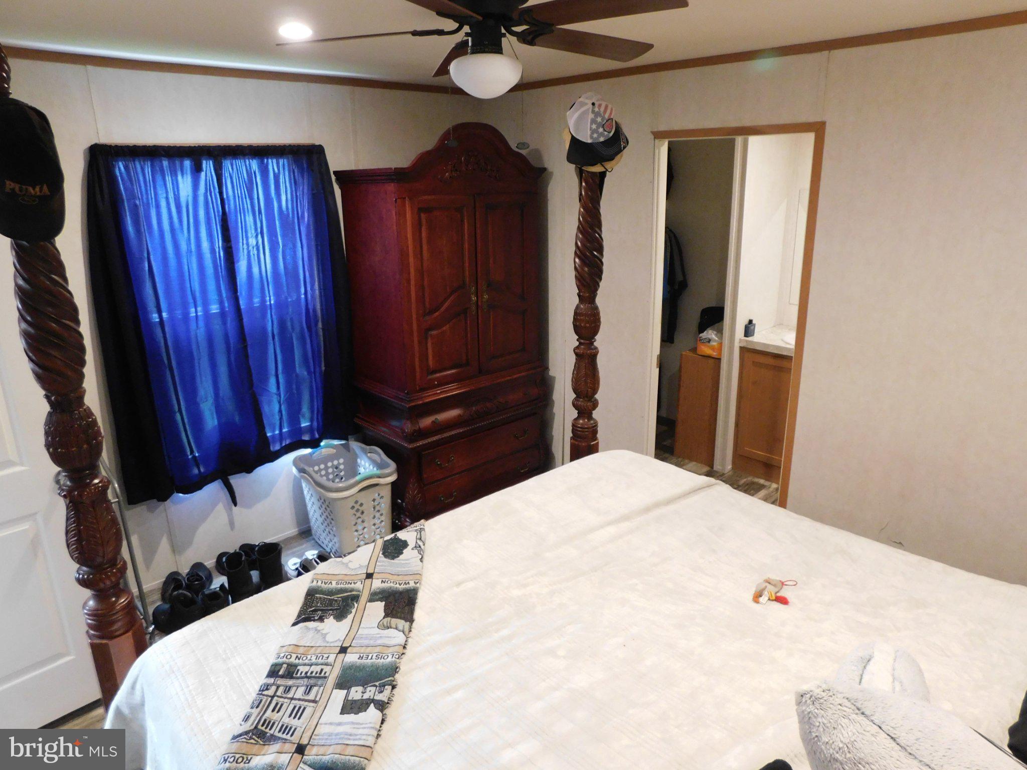 119 Meadow Lane Lititz, PA 17543 - Photo 13 of 13 a bedroom with a bed a dresser and a chandelier
