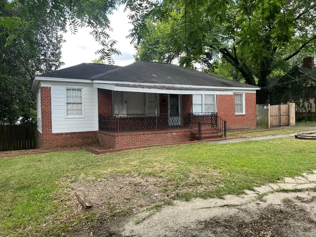 a backyard of a house with table and chairs