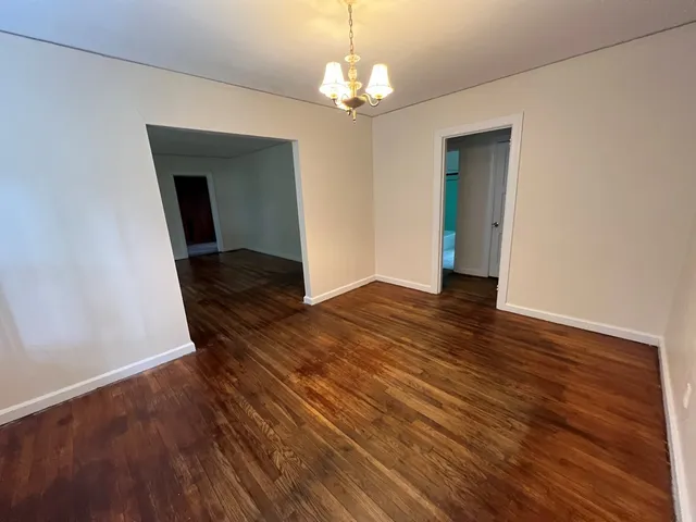 a view of a livingroom with wooden floor and staircase