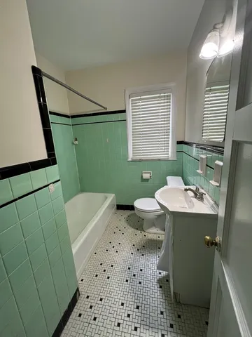 a bathroom with a sink a toilet a mirror and shower