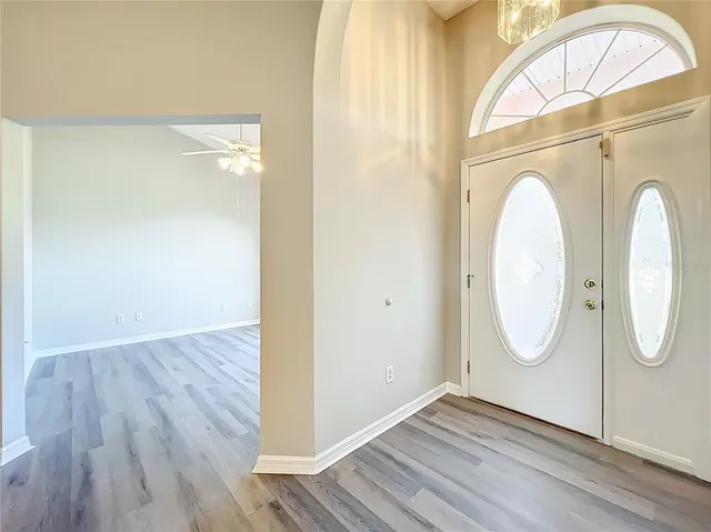 a view of empty room with wooden floor and window