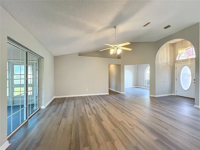 a kitchen with stainless steel appliances granite countertop a stove a sink and white cabinets with wooden floors