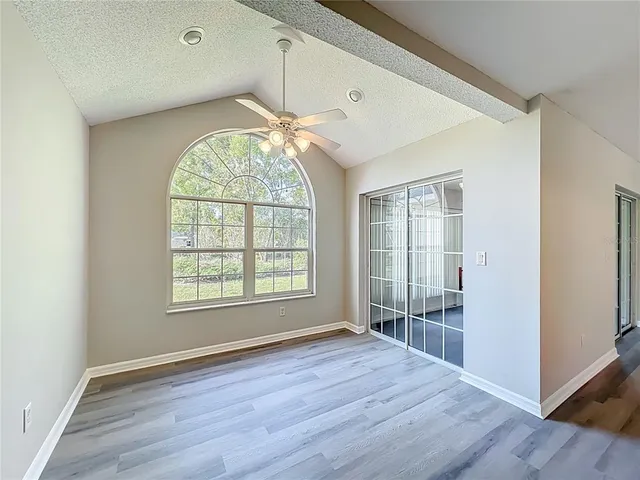 an empty room with a window and a fan