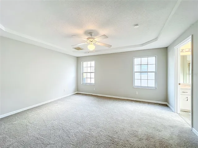 an empty room with a ceiling fan and a bathroom