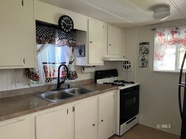 a kitchen with white cabinets and a sink