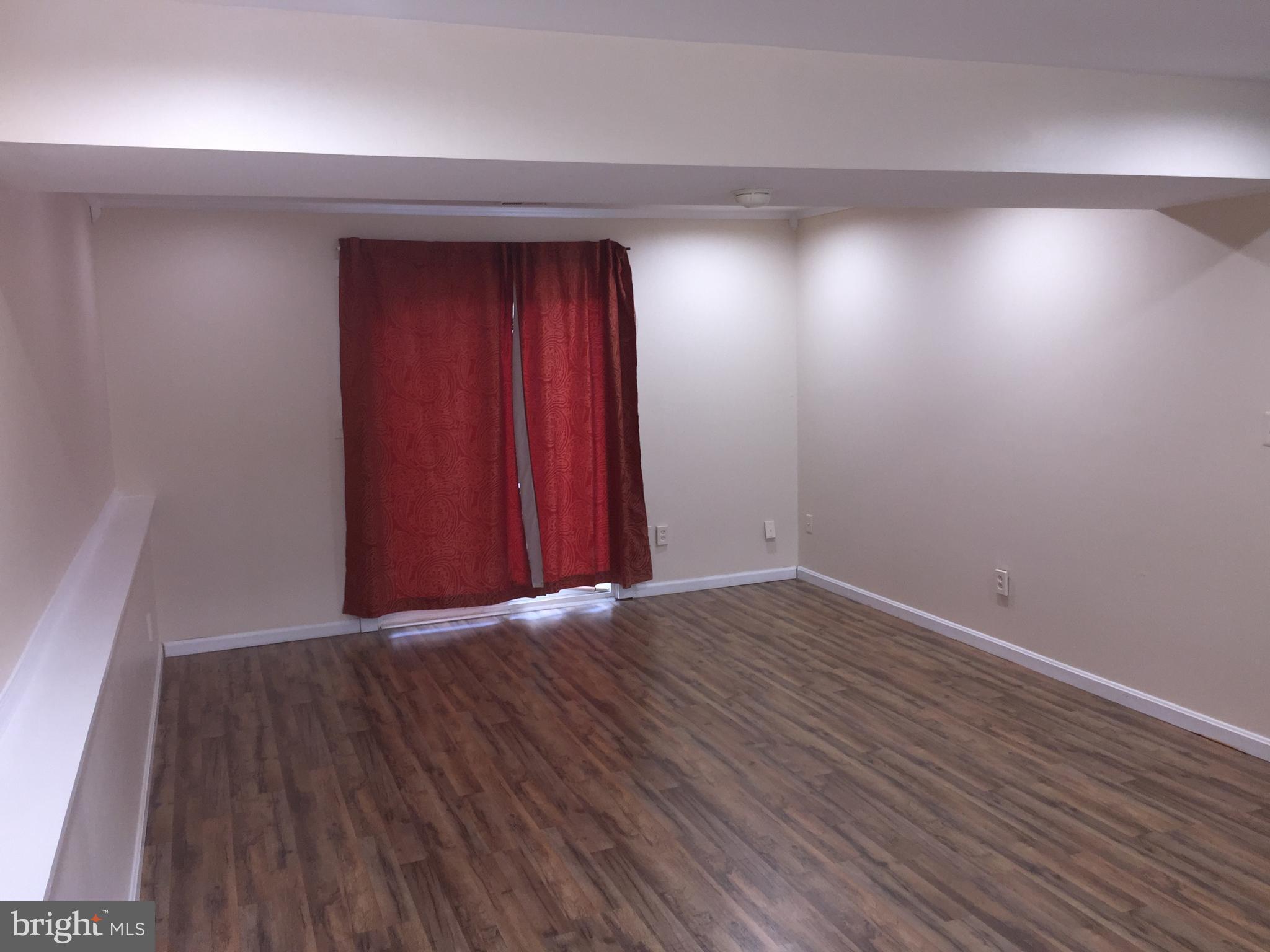 1329 Willow Spring Road Baltimore, MD 21228 - Photo 12 of 24 an empty room with wooden floor and windows