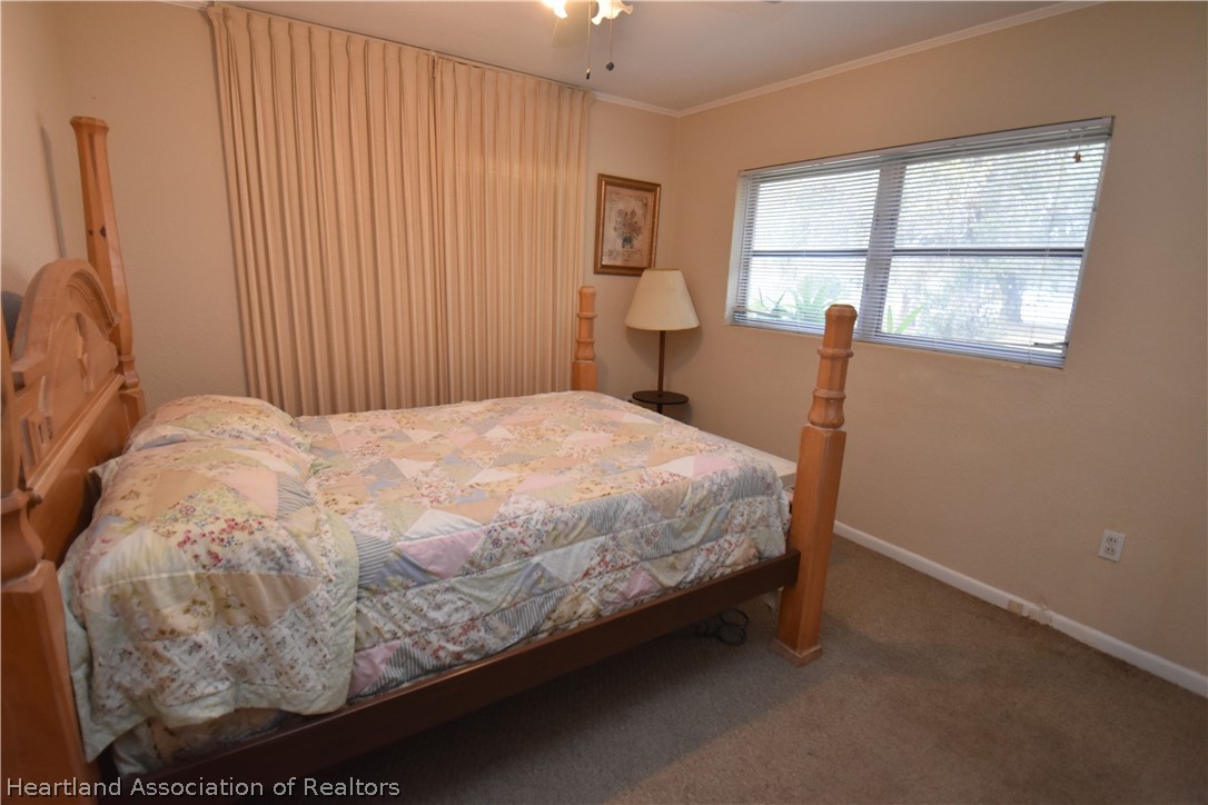 3906 Lakewood Road Sebring, FL 33875 - Photo 13 of 18 a bed sitting in a bedroom next to a window