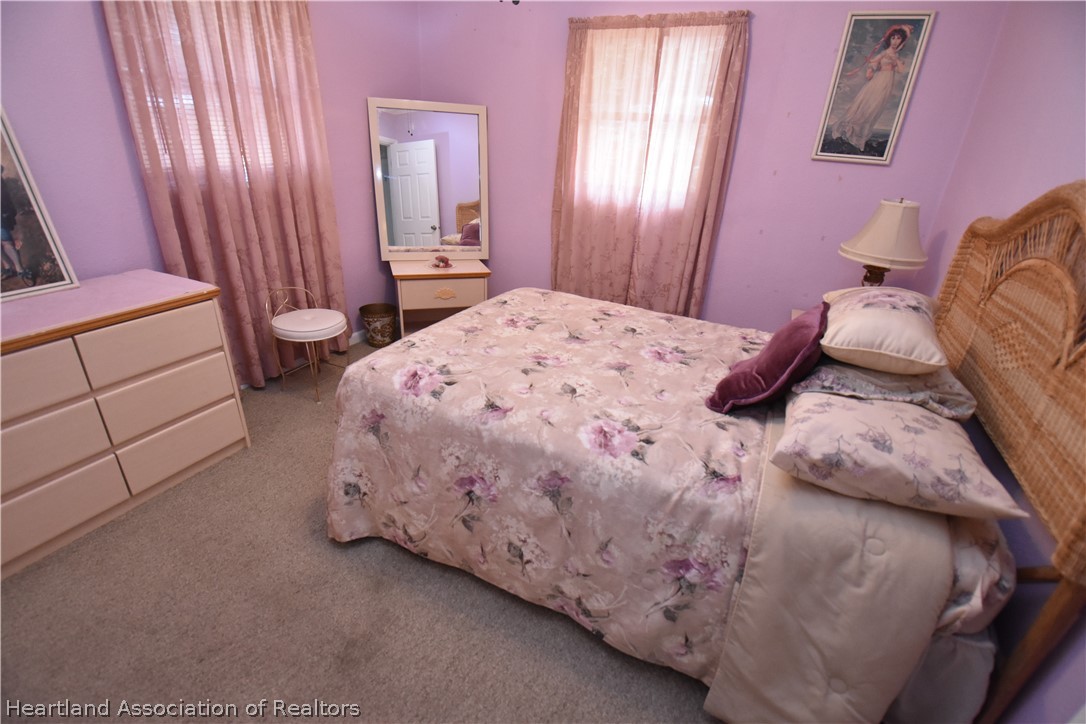 3906 Lakewood Road Sebring, FL 33875 - Photo 14 of 18 a bedroom with a bed and a mirror