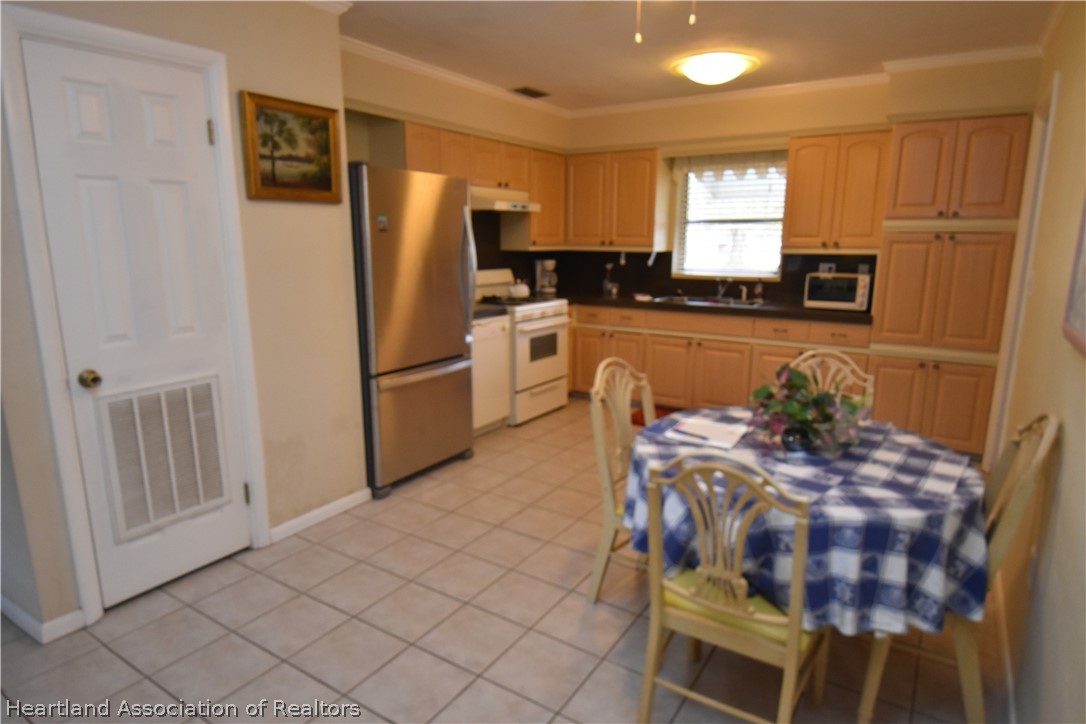 3906 Lakewood Road Sebring, FL 33875 - Photo 2 of 18 a kitchen with stainless steel appliances granite countertop a refrigerator and a stove top oven