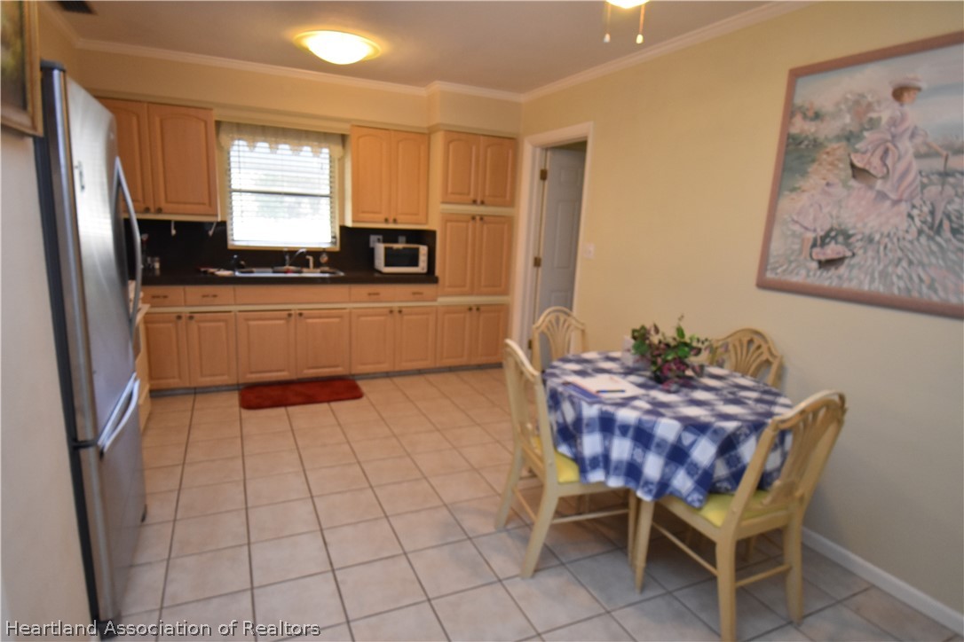 3906 Lakewood Road Sebring, FL 33875 - Photo 3 of 18 a kitchen with granite countertop a refrigerator and a stove top oven