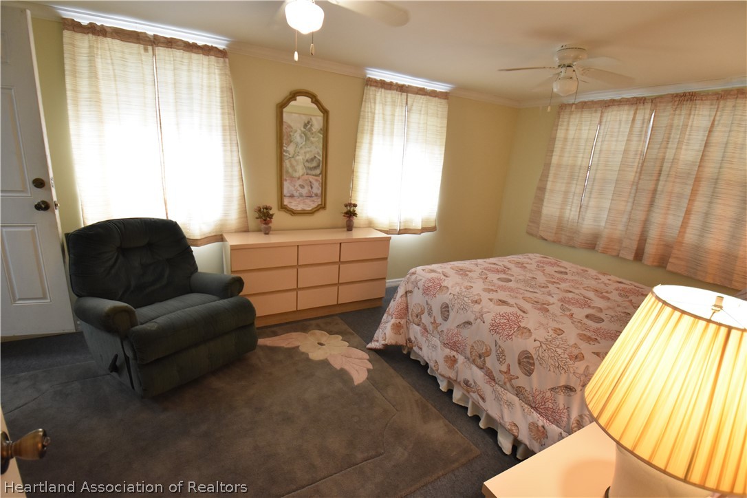 3906 Lakewood Road Sebring, FL 33875 - Photo 10 of 18 a spacious bedroom with a bed a couch and dresser
