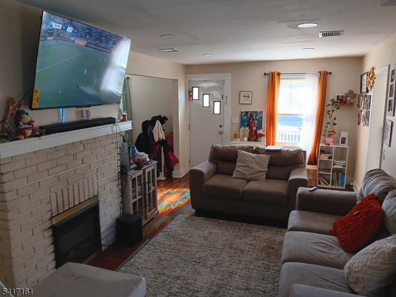 1028 West 5th Street Plainfield, NJ 07063 - Photo 6 of 13 a living room with furniture and a flat screen tv