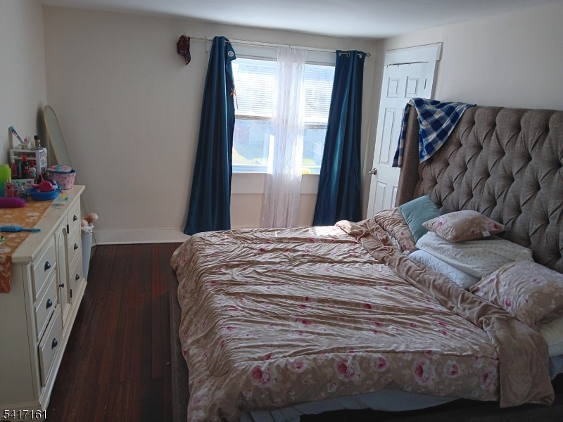 1028 West 5th Street Plainfield, NJ 07063 - Photo 8 of 13 a bedroom with a bed and wooden floor