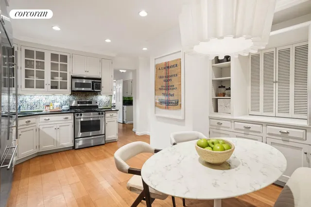 a kitchen with a stove a sink dining table and chairs